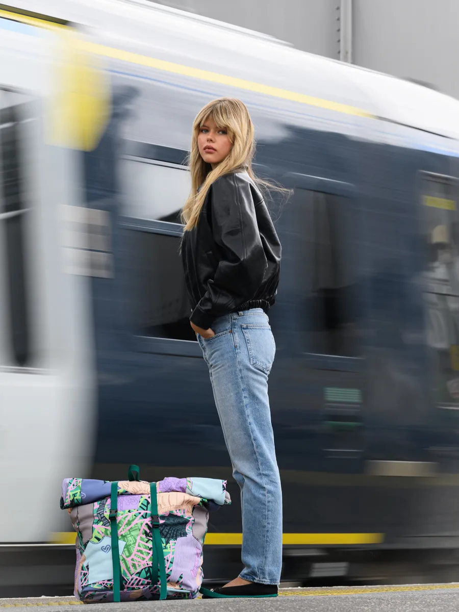 Model with the Trainline Re-Fresher Bag beside a moving train