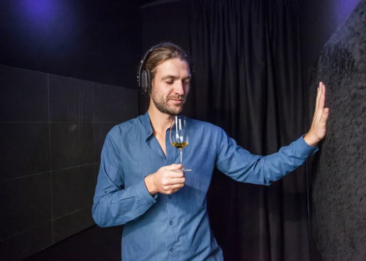 Guest with headphones nosing a Glenfiddich whisky in a sensory tasting room