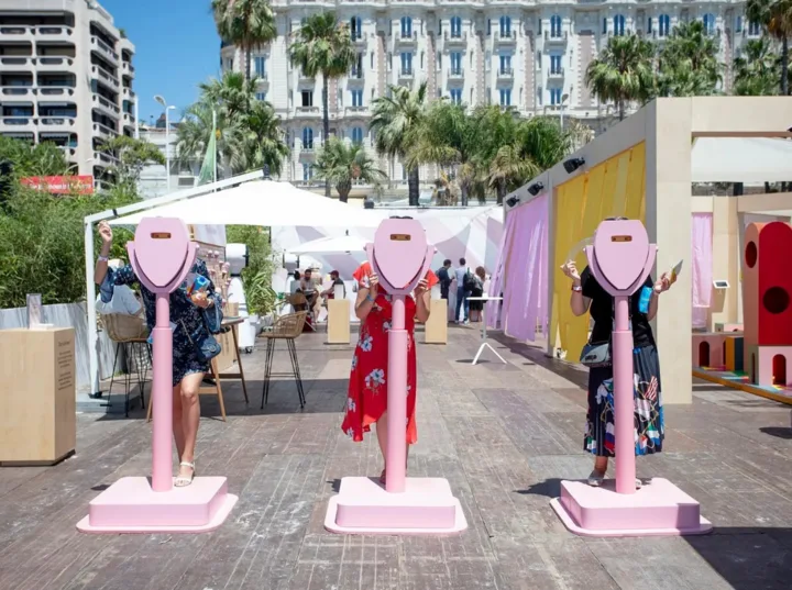 Pink Pinterest-branded viewfinders on the Cannes Lions beachfront with guests looking through them